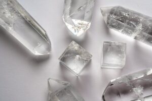 Detailed close-up of various quartz crystals arranged on a white surface.