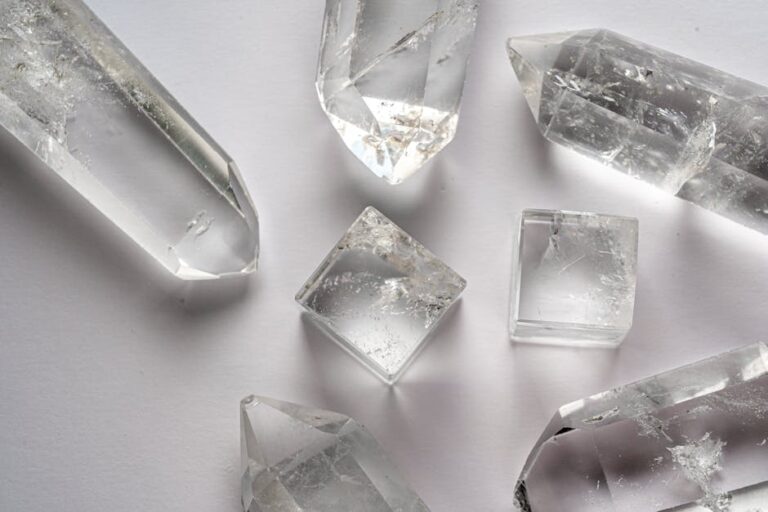 Detailed close-up of various quartz crystals arranged on a white surface.